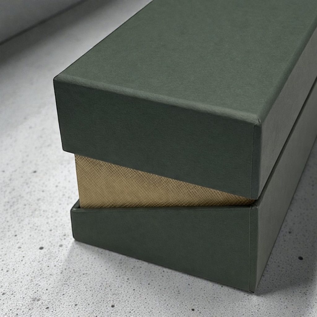 深みのあるグリーンの貼り箱とゴールド調の内装が見える高級オーダーメイドパッケージのクローズアップ