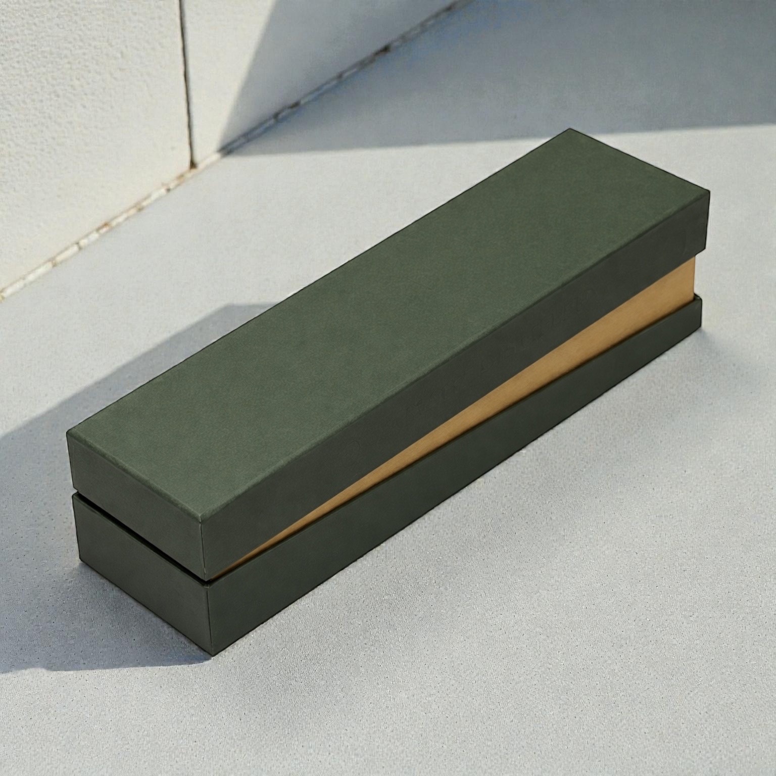 深緑の細長いオーダーメイド貼り箱。ゴールド内装がアクセントになった高級ギフトパッケージ